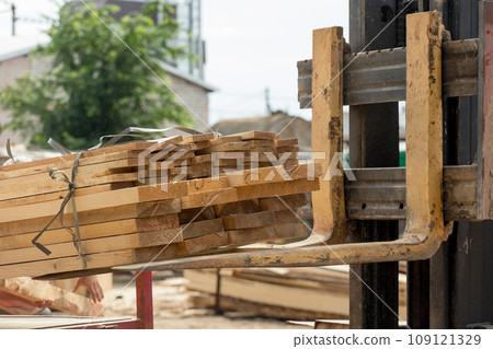 A forklift loads wooden planks, close-up. Wood industry 109121329