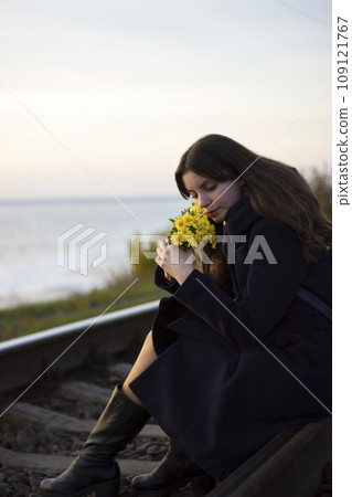Girl walks on railway rails with flowers - travel, lifestyle, love 109121767
