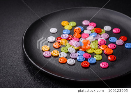 A concept consisting of the inscription of the word smile, with round emoticons on a dark concrete background 109123995