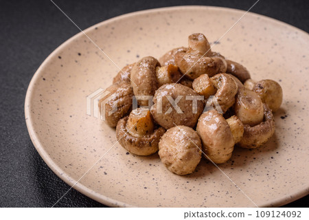 Delicious juicy whole champignons baked on the grill with salt and spices Delicious juicy whole champignons baked on the grill with salt and spices 109124092