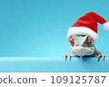 Funny chameleon in a red Santa Claus hat on a blue background. New Year or Christmas banner concept with chameleon and free space. 109125787