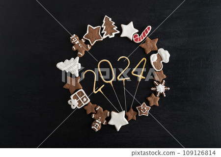 Gingerbread cookies in the shape of a circle and golden number 2024 inside, black background. New year 2024. Top view Gingerbread cookies in the shape of a circle and golden number 2024 inside, black background. New year 2024. Top view 109126814