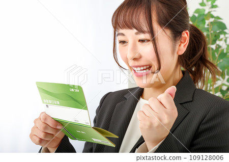 A woman looks happy when she looks at her bankbook 109128006