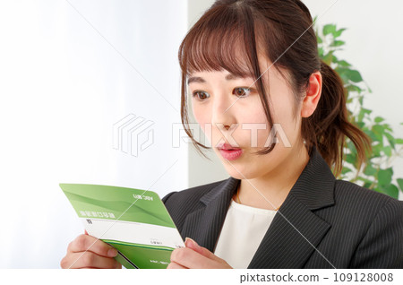 一個女人看著她的銀行存摺時看起來很高興 109128008