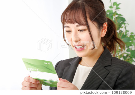 一個女人看著她的銀行存摺時看起來很高興 109128009