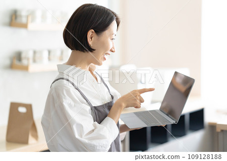 A woman in an apron with a laptop 109128188