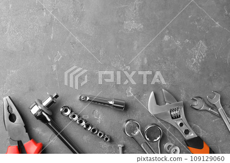 Auto mechanic's tools on grey stone table, flat lay. Space for text Auto mechanic's tools on grey stone table, flat lay. Space for text 109129060