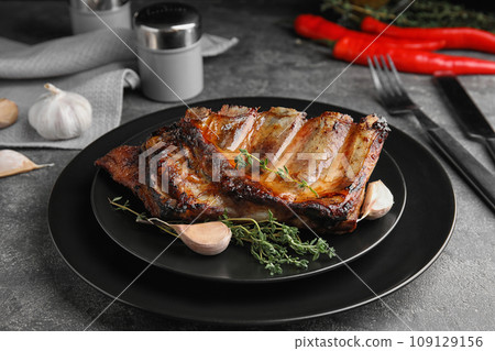 Tasty grilled ribs with thyme on grey table 109129156