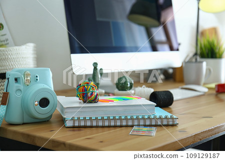 Digital camera and notebooks on table in studio. Modern designer's workplace Digital camera and notebooks on table in studio. Modern designer's workplace 109129187