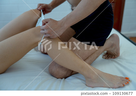Hands of man take woman underwear off at position of leg in concept of sexual of couple at home. Hands of man take woman underwear off at position of leg in concept of sexual of couple at home. 109130677