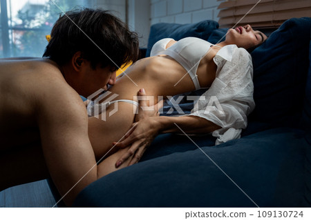 Asian man kiss on woman abdomen to soothe and make woman feel good in concept of sexual of couple 109130724