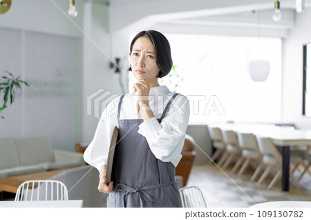 A woman in an apron thinking A woman in an apron thinking 109130782