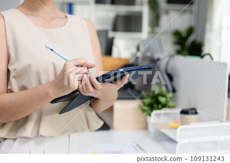 businesswoman holding tablet standing at modern office looking at camera. 109131243