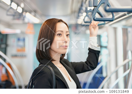 A woman stands holding a train strap A woman stands holding a train strap 109131849