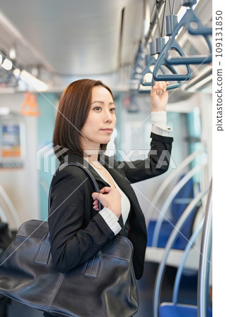 一個女人站著,手裡拿著火車帶 一個女人站著,手裡拿著火車帶 109131850