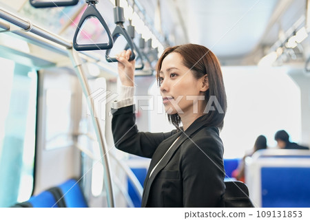 一個女人站著,手裡拿著火車帶 一個女人站著,手裡拿著火車帶 109131853