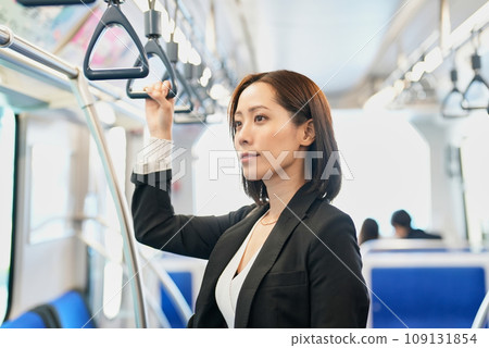 一個女人站著,手裡拿著火車帶 一個女人站著,手裡拿著火車帶 109131854