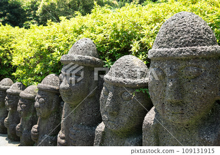 Dol hareubang stone grandpa sculpture at Cheonjiyeon Falls in Jeju Island, Korea Dol hareubang stone grandpa sculpture at Cheonjiyeon Falls in Jeju Island, Korea 109131915