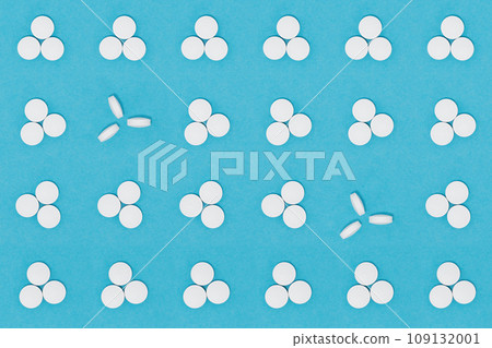 White pills on a blue background. Oblong and round pills close-up. Healthcare and medicine White pills on a blue background. Oblong and round pills close-up. Healthcare and medicine 109132001