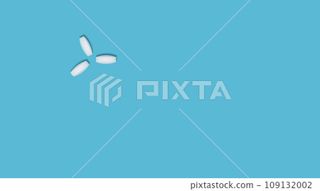 Three round white pills, vitamins on a blue background, flat lay, place for text. Concept of medicines, healthcare, immunity. Three round white pills, vitamins on a blue background, flat lay, place for text. Concept of medicines, healthcare, immunity. 109132002