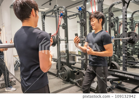Man taking a selfie in front of the gym mirror Man taking a selfie in front of the gym mirror 109132942