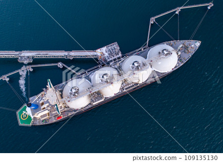 Aerial top down of Liquified Natural Gas LNG carrier moored to a small gas terminal. Fuel crisis. Sanctions 109135130