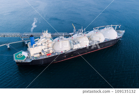 Aerial of Liquified Natural Gas LNG carrier moored to a small gas terminal. Fuel crisis. Sanctions Aerial of Liquified Natural Gas LNG carrier moored to a small gas terminal. Fuel crisis. Sanctions 109135132