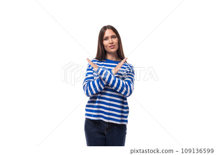 young charming brunette lady with straight hair dressed in a blue sweater crossed her arms on a 109136599