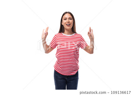 young calm european brunette woman dressed in a striped t-shirt shows that everything is super on a young calm european brunette woman dressed in a striped t-shirt shows that everything is super on a 109136617