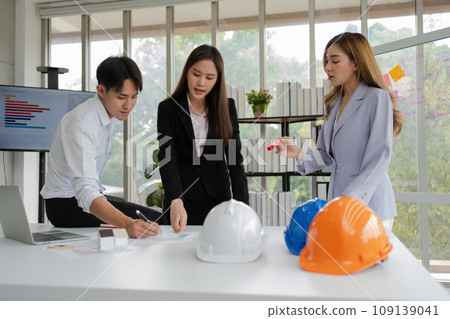 Group of Asian businesspeople and engineers working and brainstorming in office. Competent construction team having discussion during meeting. Team Architect looking at blueprints in a building site 109139041