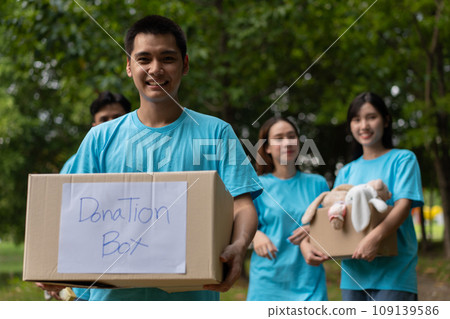 Happy young Asian students diverse volunteers hold donate box and toys for charity to share children and orphanages, a charity for sustainability. Volunteer work lifestyle and social cooperation Happy young Asian students diverse volunteers hold donate box and toys for charity to share children and orphanages, a charity for sustainability. Volunteer work lifestyle and social cooperation 109139586