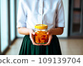 Schoolgirl child holds in her hands a jar of chewable gummy vitamins. The concept of taking vitamins to keep the child healthy while studying 109139704