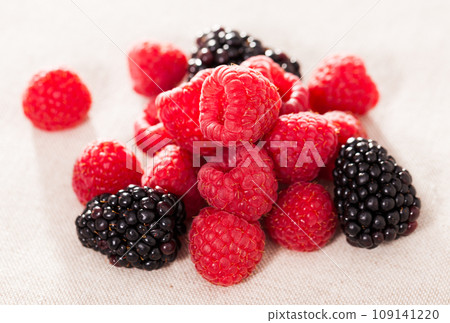 Handful of fresh raspberry and blackberry berries on white background 109141220