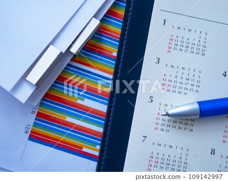 Graphs, calendars and documents on the table 109142997