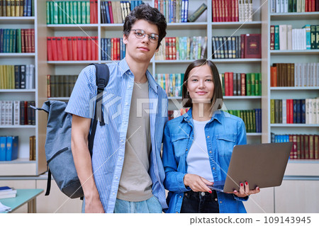 College students, guy and girl, smiling looking at camera inside library 109143945
