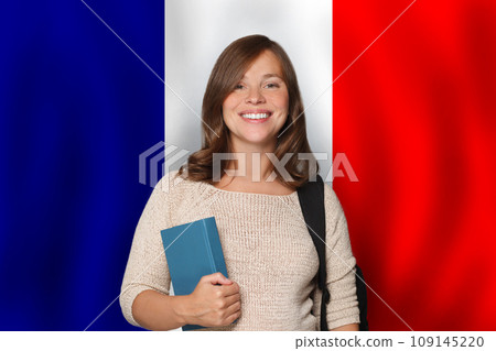 Pretty woman student against French flag background. Travel, education  109145220
