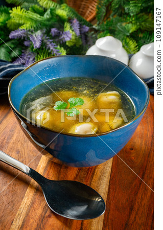 Pelmeni filled with meat served in broth. 109147167