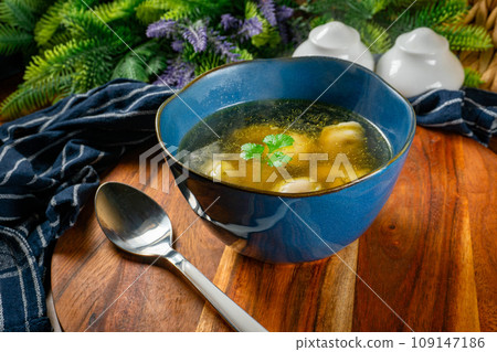 Pelmeni filled with meat served in broth. 109147186