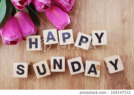 Happy Sunday alphabet letters with pink tulip flower bouquet top view on wooden background 109147532