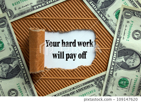 The text 'your hard work will pay off' appearing behind torn brown paper. Dollar bills. Business concept. 109147620