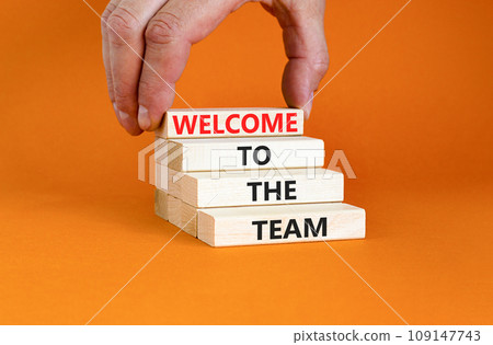 Welcome to the team symbol. Concept words Welcome to the team on wooden block. Beautiful orange table orange background. Businessman hand. Business, motivational and welcome to the team concept. Welcome to the team symbol. Concept words Welcome to the team on wooden block. Beautiful orange table orange background. Businessman hand. Business, motivational and welcome to the team concept. 109147743