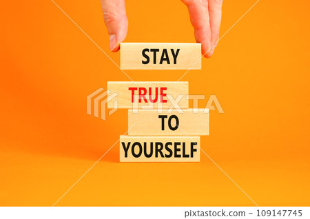 Stay true to yourself symbol. Concept word Stay true to yourself on beautiful wooden block. Beautiful orange table background. Businessman hand. Business stay true to yourself concept. Copy space Stay true to yourself symbol. Concept word Stay true to yourself on beautiful wooden block. Beautiful orange table background. Businessman hand. Business stay true to yourself concept. Copy space 109147745