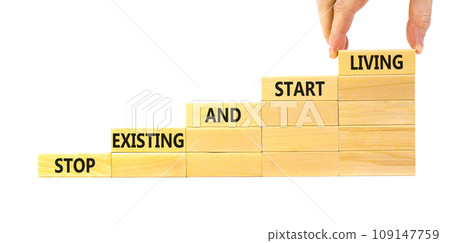 Stop existing start living symbol. Concept words Stop existing and start living on wooden blocks. Beautiful white table white background. Business Stop existing start living concept. Copy space. 109147759