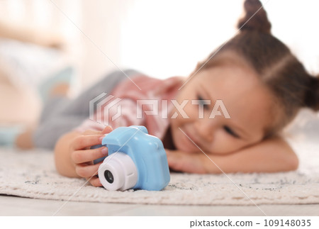 Little photographer indoors, focus on hand with camera 109148035