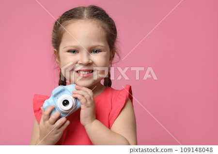 Little photographer with toy camera on pink background 109148048