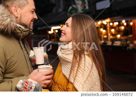 Happy couple with mulled wine at winter fair Happy couple with mulled wine at winter fair 109148072