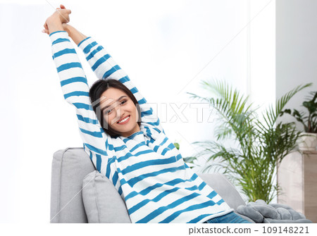 Young woman relaxing on couch at home Young woman relaxing on couch at home 109148221