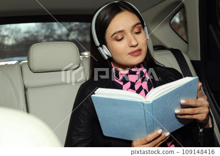Young woman listening to audiobook in car 109148416