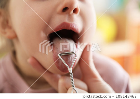 Speech therapist using logopedic probe on session with little girl in office, closeup Speech therapist using logopedic probe on session with little girl in office, closeup 109148462