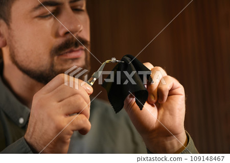 Jeweler working with ring on blurred background, closeup Jeweler working with ring on blurred background, closeup 109148467